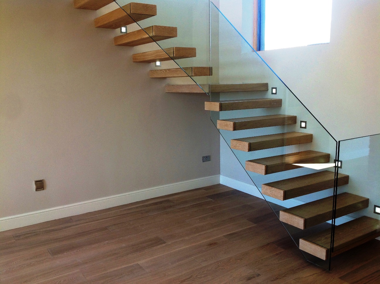 Floating limed European oak stairs with inset glass balustrade